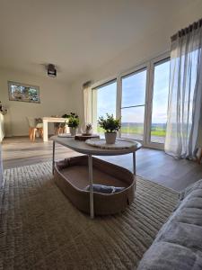 a living room with a table and a large window at Panorama trifft Gemütlichkeit in Nümbrecht