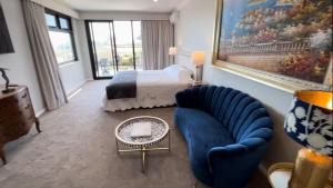 a bedroom with a bed and a blue chair at Beach House Perth in Perth