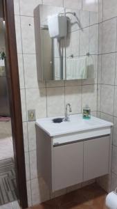 un bagno con lavandino e specchio di Aconchego II a Foz do Iguaçu
