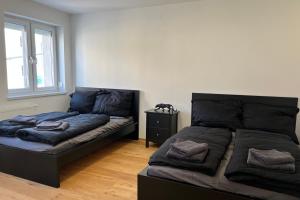 1 Schlafzimmer mit 2 Betten und einem Nachttisch in der Unterkunft Cozy City Center Designer Apartment for 10 People in Wiener Neustadt + 9 Fotos
