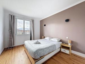 ein weißes Schlafzimmer mit einem Bett und einem Fenster in der Unterkunft Appartement sur Riom 6 pers in Riom