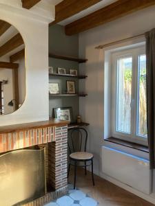 ein Wohnzimmer mit einem Kamin und einem Fenster in der Unterkunft Maison avec jardin à Sully Sur Loire in Sully-sur-Loire