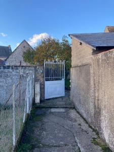 ein Tor in einer Backsteinmauer neben einem Zaun in der Unterkunft Maison avec jardin à Sully Sur Loire in Sully-sur-Loire