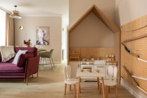 a living room with a purple couch and a table at Red Roof Apartments Old Town in Krakow
