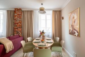 a living room with a table and a red couch at Red Roof Apartments Old Town in Krakow +39 photos