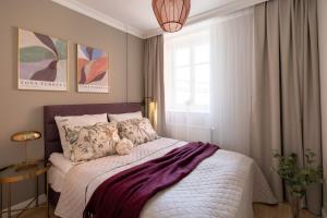 a bedroom with a bed with a teddy bear on it at Red Roof Apartments Old Town in Krakow
