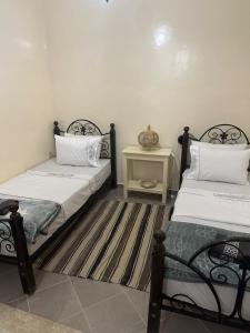 - une chambre avec 2 lits et une table de nuit dans l'établissement Calm & Comfortable Tafraout Apartment for families Ground Floor, à Tafraout
