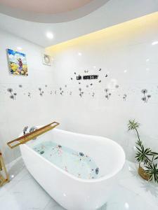 Un baño blanco con bañera y un cartel en la pared. en LUA Homestay, en Vĩnh Long 23 fotos más