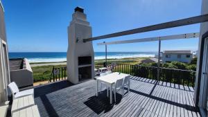 a balcony with a table and a view of the ocean at Seaview Sunsets in Gqeberha