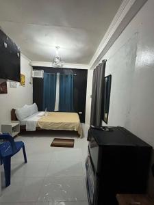 a bedroom with a bed and a television in it at Dean's Homestay Siargao in General Luna