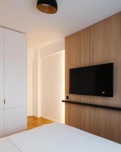 a bedroom with a bed and a flat screen tv at Campus - Palas Moonlight in Iaşi