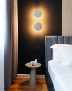 a bedroom with a bed and a table with a alarm clock at Campus - Palas Moonlight in Iaşi