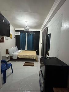 a bedroom with a bed and a tv in a room at Dean's Homestay Siargao in General Luna +9 photos