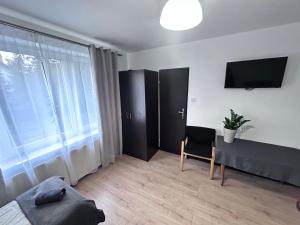 a living room with a table and a television at Kozienice Dream Hostel 