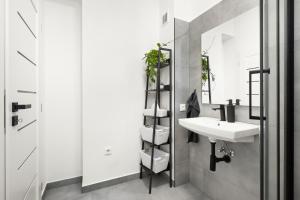 a white bathroom with a sink and a mirror at SPECTRA Rooms in Velké Meziříčí +30 photos