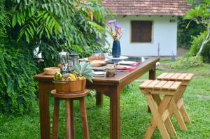 a wooden table with food on it in a yard at EcoBlueprint Garden in Pannala