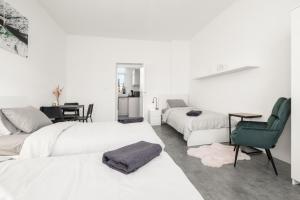 a bedroom with three beds and a table and a chair at SPECTRA Rooms in Velké Meziříčí