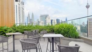 吉隆坡majestic Resort Suites KLCC的一个带桌椅的庭院,享有城市天际线