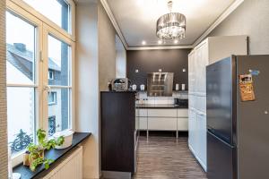 eine Küche mit einem großen Fenster und einem Kühlschrank in der Unterkunft Altes Kappellchen im alten Schwesternhaus in Weibern + 9 Fotos