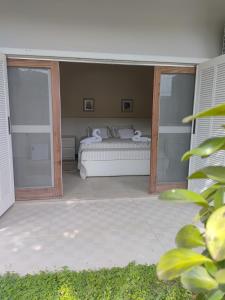 a bedroom with a bed in a room with sliding glass doors at La Salamandre Paraty in Paraty