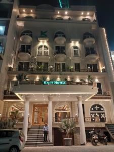 Un uomo in piedi di fronte a un grande edificio di HOTEL KAVERI , a boutique hotel a Zirakpur