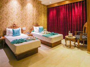 una camera da letto con due letti e una tenda rossa di HOTEL KAVERI , a boutique hotel a Zirakpur Altre 31 foto