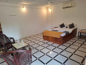 une chambre avec un lit, une table et des chaises dans l'établissement The Bella Vista Retreat, à Sāsan Gīr