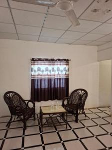 une chambre avec trois chaises, une table et une fenêtre dans l'établissement The Bella Vista Retreat, à Sāsan Gīr