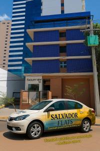 a yellow car parked in front of a building at Bahia Flats Facility View in Salvador