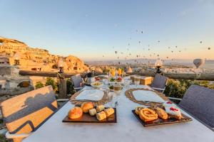 uma mesa com comida e vista para a cidade em Eyes Of Cappadocia Cave Hotel em Üçhisar