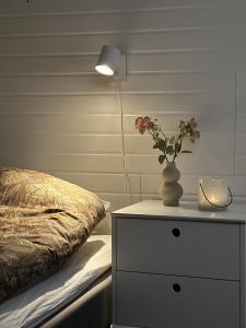 耶利瓦勒Företagsboende i Gällivare, 7 sovrum的一张桌子,上面有花瓶,放在床边