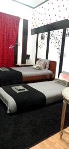 zwei Betten in einem Zimmer mit roten Punkten an der Wand in der Unterkunft Trikala centro La vita è bella in Tríkala