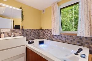 uma banheira grande em um banheiro com janela em Chalet & Spa Nora em Stekene
