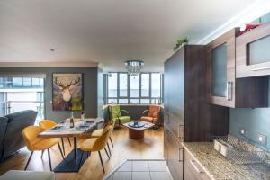 a kitchen and living room with a table and chairs at Blue Pool View in Portrush