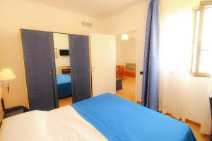 a bedroom with a blue and white bed and a mirror at Hotel Paladini di Francia in Lampedusa