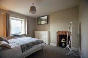 a bedroom with a bed and a fireplace at Homely Cottage - Beaches, Costal walks, Castles in Newchapel