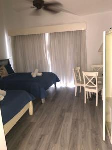 a bedroom with a bed and a table and chairs at Cadaques caribe bayahibe in La Laguna