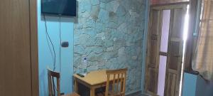 a table and chairs in a room with a stone wall at Ashara guesthouse in Āwasa