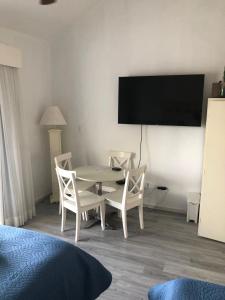 a room with a table and chairs and a flat screen tv at Cadaques caribe bayahibe in La Laguna