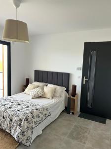 une chambre avec un lit avec une couette noire et blanche dans l'établissement Au Pied du Pic Saint Loup, à Saint-Mathieu-de-Tréviers