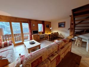 a living room with a couch and a table at Les Airelles A21 in Les Menuires