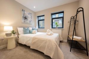 a bedroom with a white bed and two windows at Stylish 2BR Retreat - Sleeps 6 - Central Chatham in Chatham