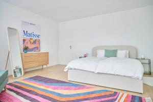 a bedroom with a bed and a mirror and a rug at Central rooftop apartment with AC and city view in Basel