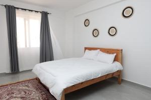 Un dormitorio con una cama con sábanas blancas y una ventana. en Fazami001, en Mombasa 10 fotos más