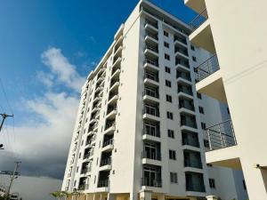 Un alto edificio de apartamentos blanco contra un cielo azul. en Fazami001, en Mombasa