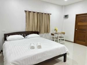 パーイにあるบ้านครูแนนปายのベッドルーム1室(大きな白いベッド1台、靴2本付)