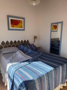 a bedroom with a bed with a blue blanket at Las Grutas Star in Las Grutas +16 photos