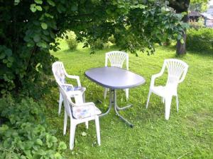 three white chairs and a table in the grass at Ferienhaus in Scheifling nahe Skipisten in Scheifling