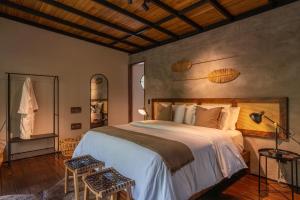 a bedroom with a large bed and two chairs at Hotel Banyan Doradal in Puerto Triunfo