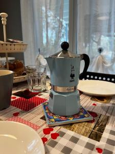 eine Kaffeemaschine auf einem Tisch mit Tellern in der Unterkunft B&B Il Gelso - San Pietro in Casale in San Pietro in Casale